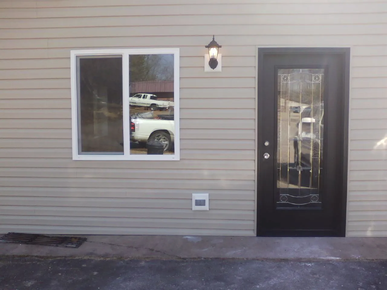 New siding, window and entry door on the side of an addition in Bonaparte