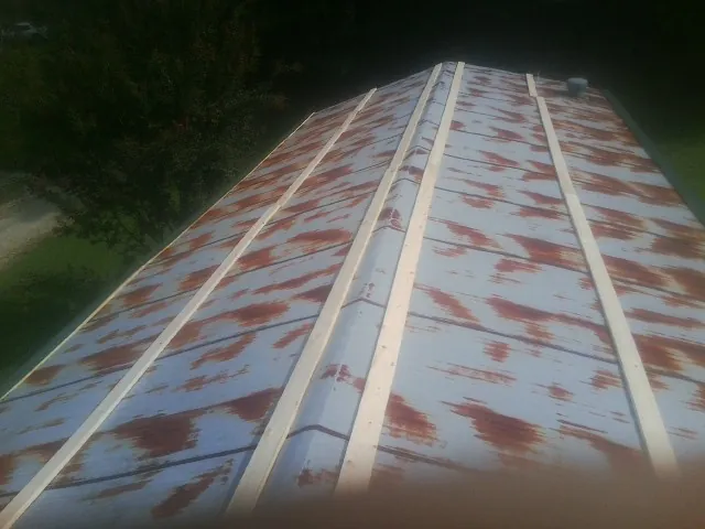 Rusted metal roof panels with new wood purlins before replacement — Storm Damage Roof Repair in Bonaparte by Roofing Brothers